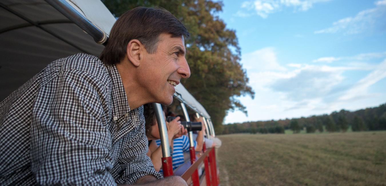 Representative Vitali looking onward from wagon riding through farmland